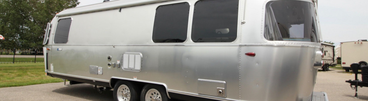 An Airstream® Tommy Bahama® parked in a storage lot on a gray day.